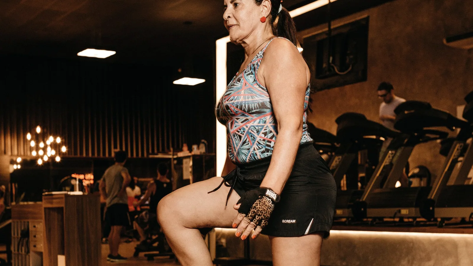 Vrouw voert een step-up uit op een fitnessbox tijdens krachttraining