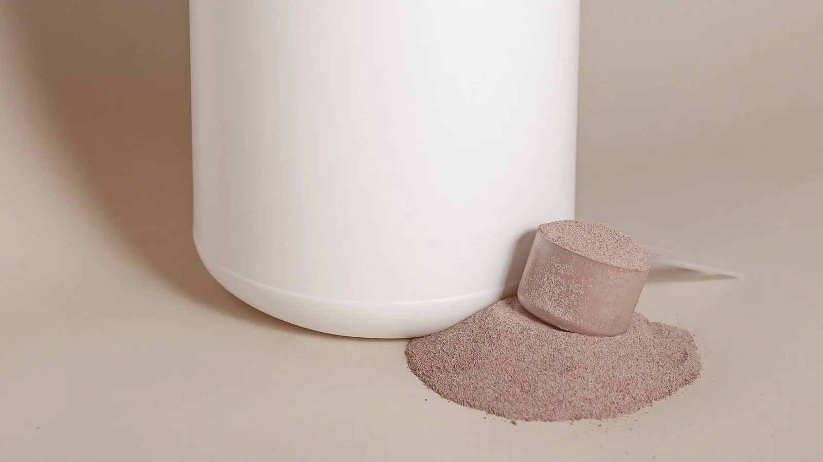 Wit supplementenpoeder met een maatschepje en een pot zonder etiket