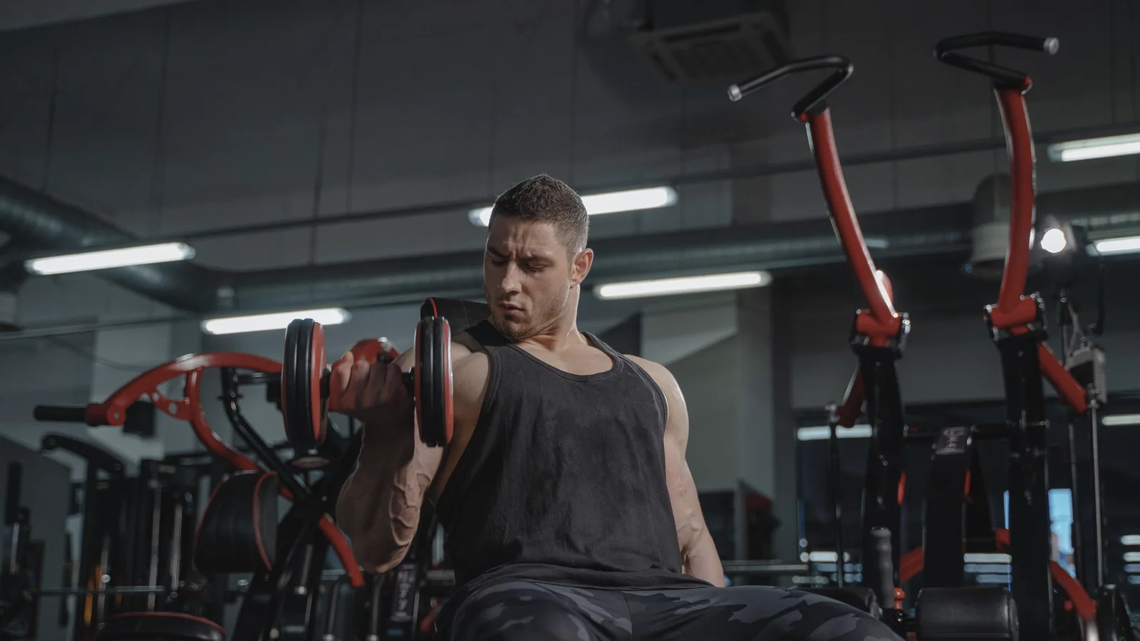 Man doet een dumbbell-curl tijdens krachttraining