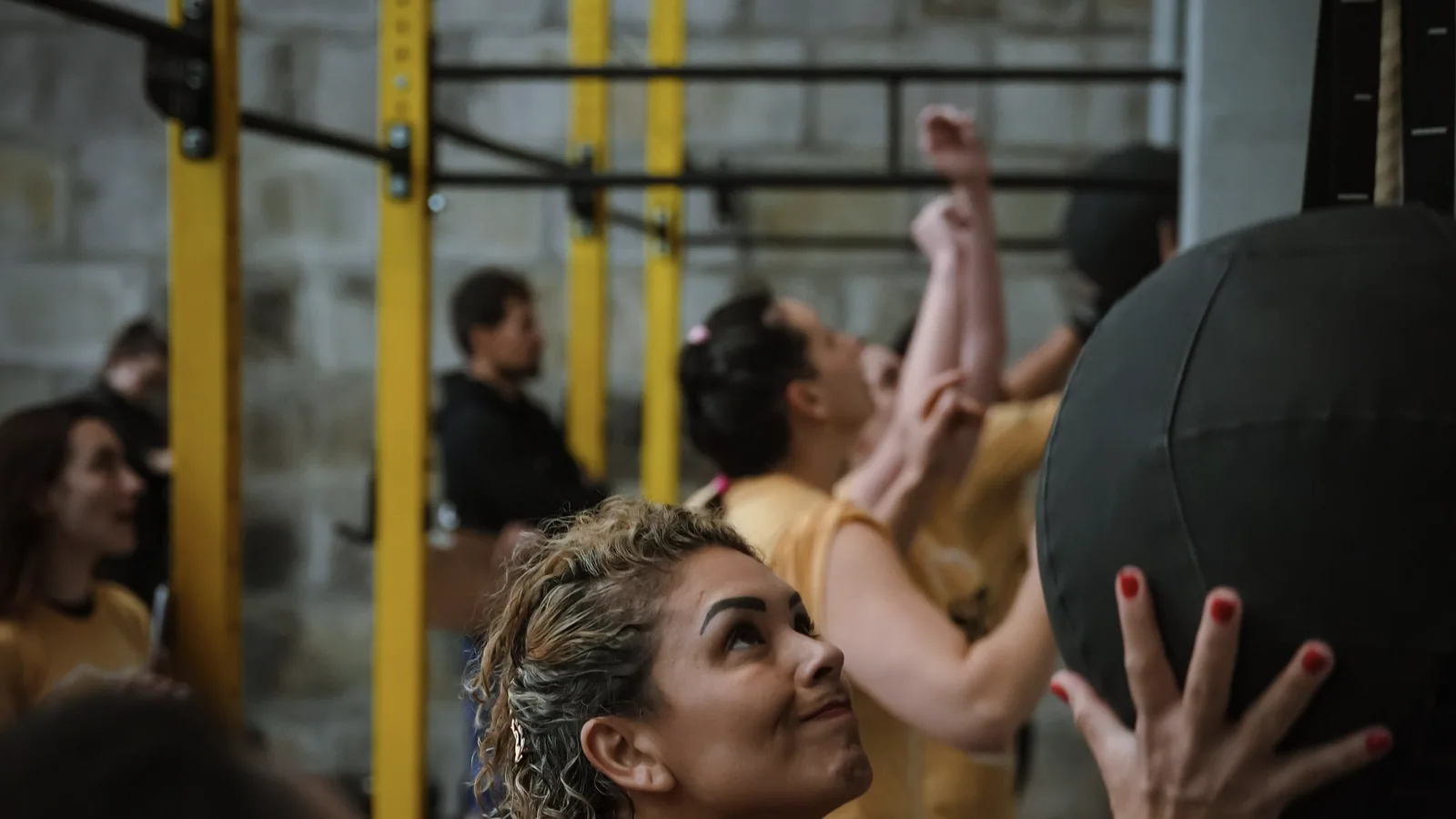 Sporters oefenen wall balls tijdens een functionele groepstraining, ter illustratie van HYROX